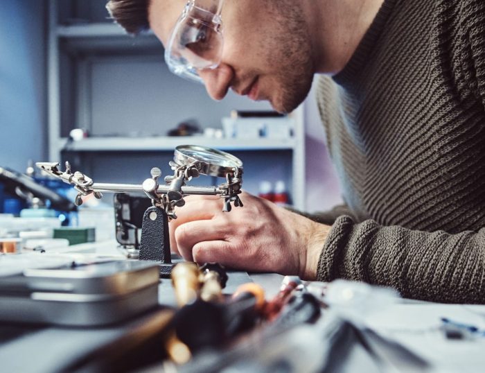 a male engineer working on a machine to create a product